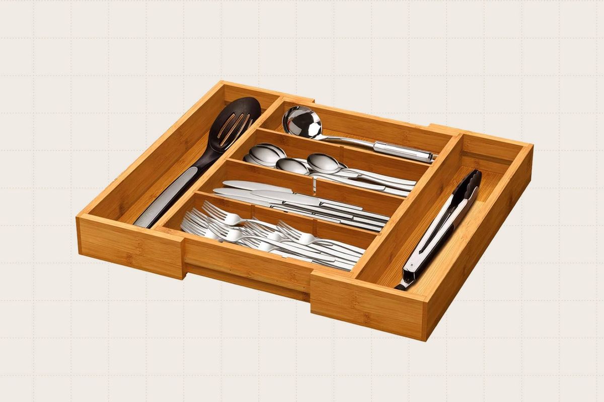 The Pipishell Bamboo Expandable Drawer Organizer pictured against a plain beige background. It has 4 removable dividers so you can create a custom storage solution. This kitchen cutlery tray is expandable from 10.24" to 15.75" wide, 13.98" long, and 1.97" deep.