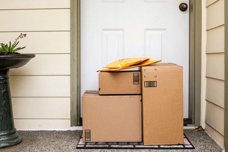 Five Amazon packages on a front doorstep. Some are boxes, others are envelopes.