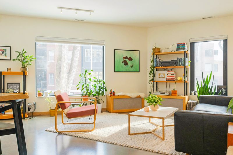 An apartment living room with several pieces of furniture in the same warm wood tone.