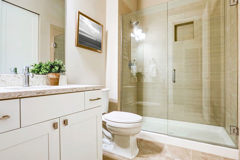 A clean, modern bathroom with large glass shower doors.