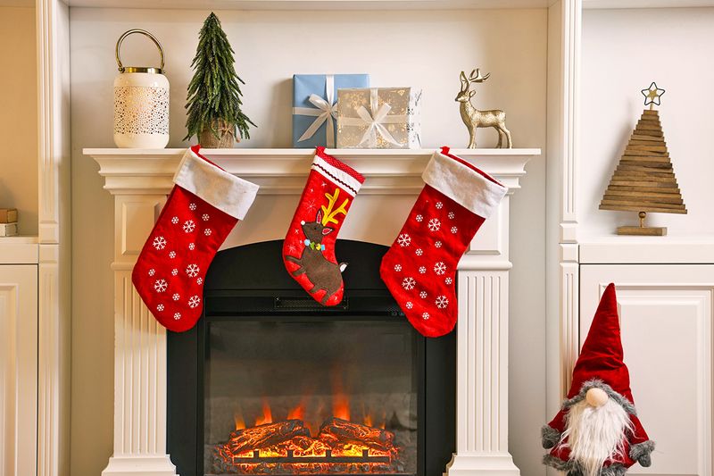 A fireplace with three Christmas stockings hanging from the mantel.