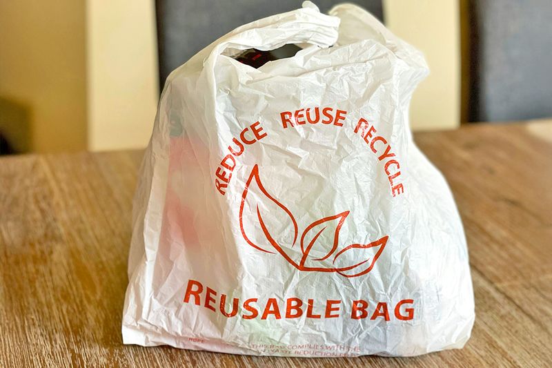 A plastic bag with handles that says "Reusable Bag" across it.