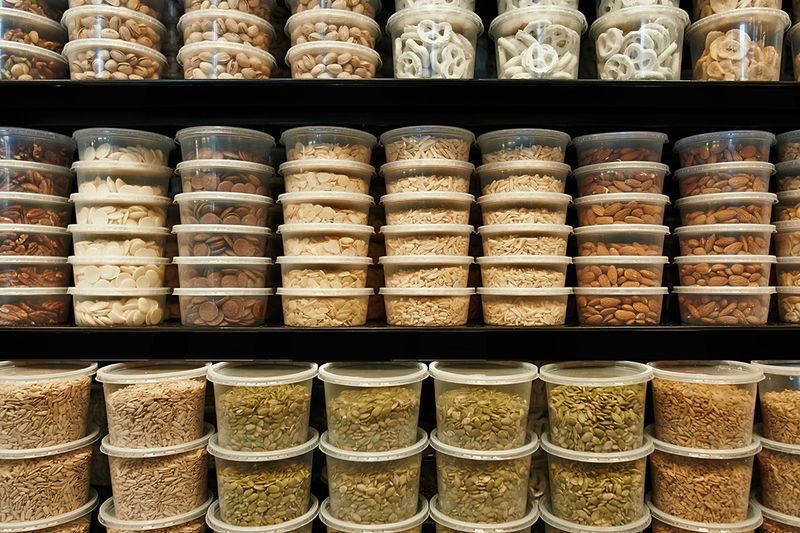 A close-up of store shelves with packaged goods in different size deli containers.