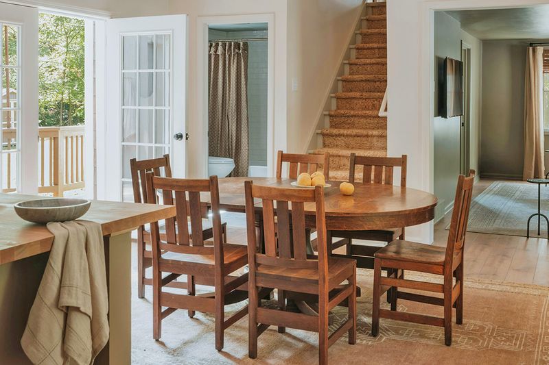 A wood, oval-shaped dining table with matching wood dining chairs in an open-concept dining space.