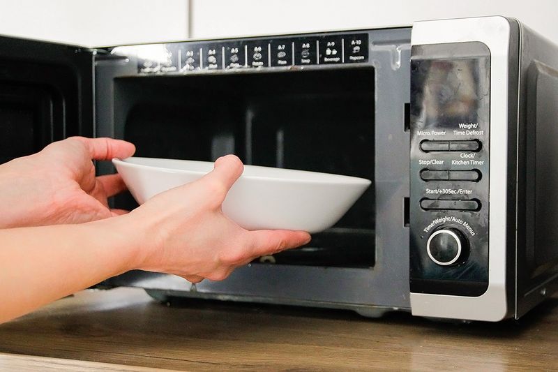 Putting a bowl of food in a microwave